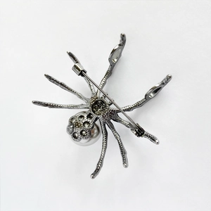 Detailed back view of spider brooch showing metal pin clasp and hollow-out structure