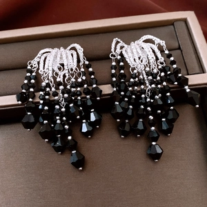 Detailed view of vintage silver earrings with black faceted glass bead tassels