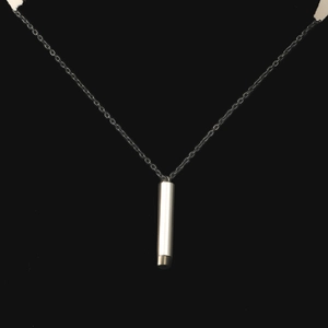 Macro view of mirror polished stainless steel cylindrical telescopic stick pendant necklace
