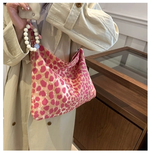 Pink leopard canvas tote bag with white pearl beaded handle detail on a model