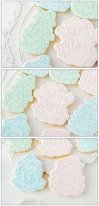 Detailed view of fairy house and mushroom embossed cookies in soft pink and blue frosting