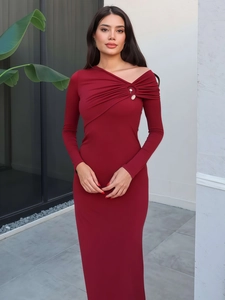Close-up of asymmetrical off-shoulder neckline and radial pleats on dark red knit dress