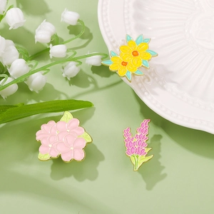 Three elegant floral enamel pins featuring hydrangea lavender and daisy designs on a plate