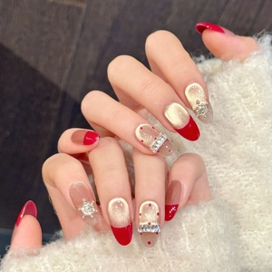 Detail of red and gold winter press-on nails with 3D snowflakes and crystals