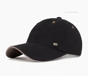 Detail of black cotton baseball cap featuring a premium golden metal logo and curved brim