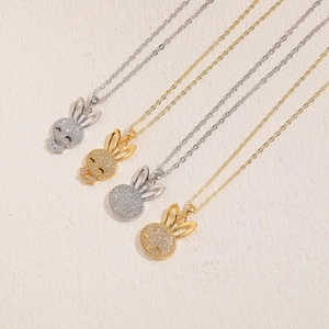 Flat lay of rabbit zircon necklaces in gold and silver finish with crystal pavé details