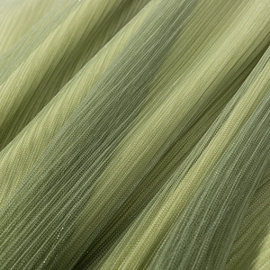 Detailed macro view of green pleated mesh fabric with subtle shimmer and flowing texture