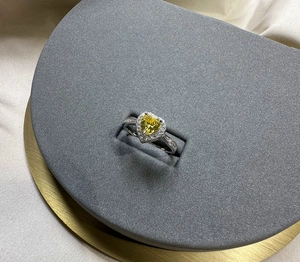 Macro detail of a 6mm heart-shaped yellow diamond ring in a silver halo setting