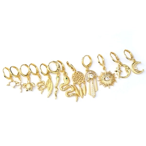 Polished gold snake, cross, and feather charm earrings set for women in minimalist style