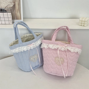 Dettaglio ravvicinato di borse trapuntate a cuore rosa e a righe blu con pizzo decorativo