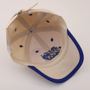 Interior detail of beige and blue cotton baby baseball cap showing seams and quality finish