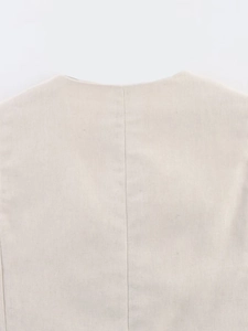 Detailed view of the V-neck vest back seam and texture in beige cotton linen fabric