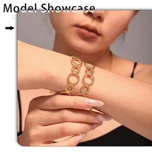 Gedetailleerde close-up van goudkleurige getordeerde schakels op een bangle armband