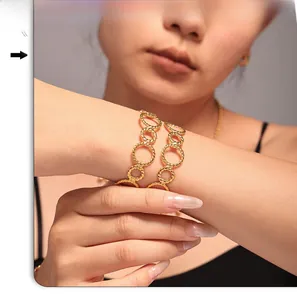 Detailed close-up of gold-plated twisted cable chain links on a minimalist bangle
