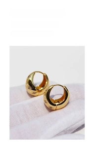 Detail view of gold-plated starburst hoop earrings with micro-set zircon stones