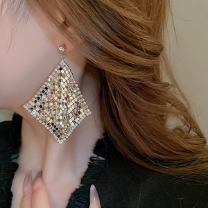 Macro detail of oversized silver mesh diamond earrings with sparkling sequins