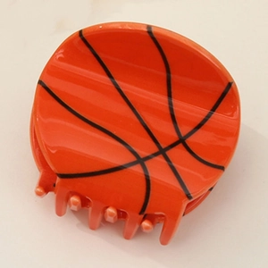 Detail shot of a round basketball-shaped claw clip with classic orange and black texture