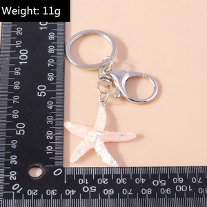 Macro shot of pink resin starfish keychain with glitter, 11g weight and size reference