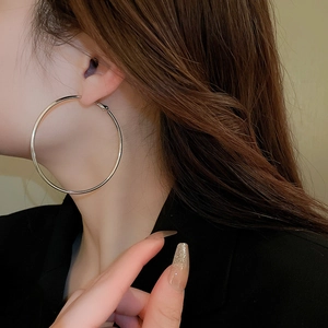 Silver-toned polished hoop earrings shown on a model for a stylish minimalist fashion look
