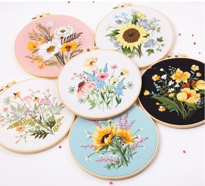 Detailed close-up of six round wooden embroidery hoops with assorted floral patterns