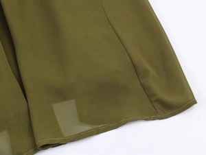 Detail of olive green chiffon dress hem with fine stitching and pleated fabric texture