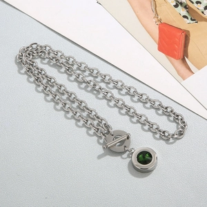 Macro view of stainless steel chunky chain necklace with OT buckle and green stone pendant