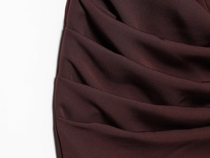 Close-up of elegant reddish brown dress fabric with smooth texture and soft pleats
