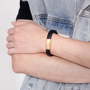 Gros plan d'un bracelet en cuir tressé noir pour homme avec fermoir en acier doré
