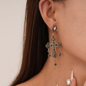 Boucles d'oreilles croix baroques avec perles et cristaux portées par un mannequin