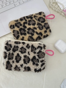 Leopard print plush cosmetic pouch and coin purse with pink strap on desk