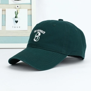 Close-up of deep green cotton baseball cap featuring white The Number 6 embroidery