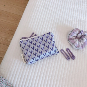 Détail de la mini pochette en toile jacquard avec motif floral violet et fermeture