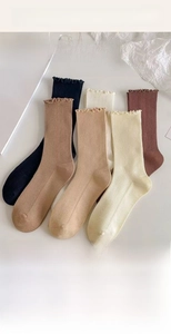 Detailed display of five earth-toned ribbed knit socks with elegant ruffled edges