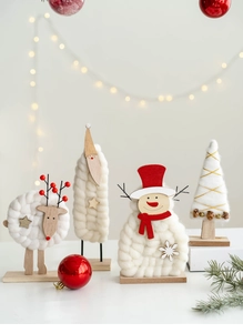 Detail of wool felt Christmas snowman and Santa figures with natural wood base decoration