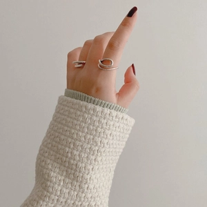 Detail showing two minimalist S925 sterling silver rings with curved and double-band designs