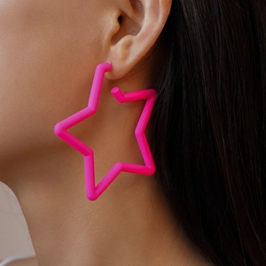 Gros plan d'une boucle d'oreille étoile en acrylique rose mat portée par un mannequin