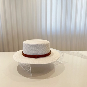 White boater straw hat with brown leather band displayed on a marble surface