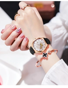 Dettaglio dell'orologio meccanico oro rosa con finestra a cuore e cinturino in pelle