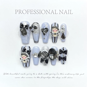Handmade press-on nails set with 3D dolls, black bows, and silver glitter blue design