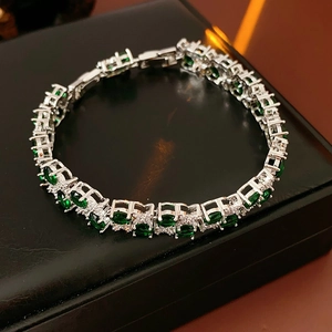 Detailansicht Silberarmband mit grünen Edelsteinen und Zirkonia auf schwarzer Schmuckschatulle
