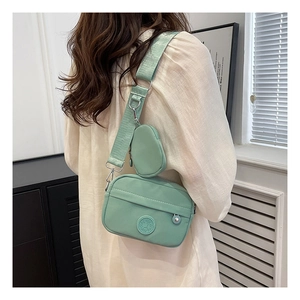 Detail of mint green oxford crossbody bag with adjustable wide strap and round coin purse