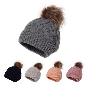 Winter knitted baby beanie hat with faux fur pompom shown in five assorted solid colors