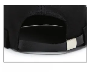 Detail of adjustable leather strap and silver metal buckle on black brimless docker hat