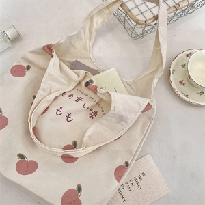 Detail of peach print canvas tote bag with taste of peaches text and wide handle