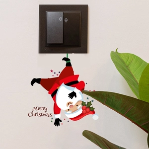 Close-up of a festive red Santa Claus PVC wall sticker applied below a light switch