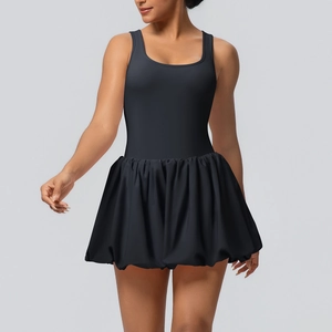 Detail of a black sleeveless athletic dress with layered pleated hem and slim-fit bodice