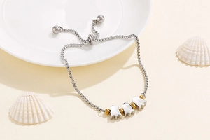 Detail of adjustable stainless steel bracelet featuring three tulip-shaped metal charms
