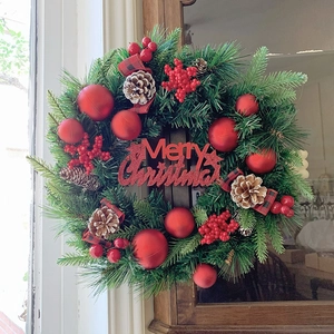 Traditioneller Weihnachtskranz mit Tannennadeln, roten Beeren und Merry Christmas Schild