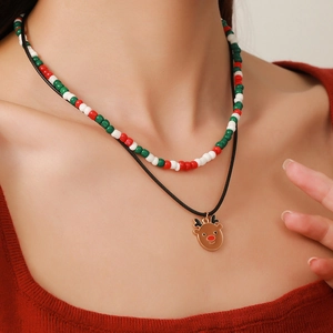Close-up of double-layered Christmas necklace with festive beads and reindeer charm