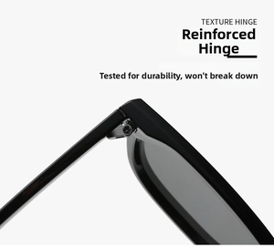 Detail of reinforced metal hinge on black oversized square sunglasses for durability